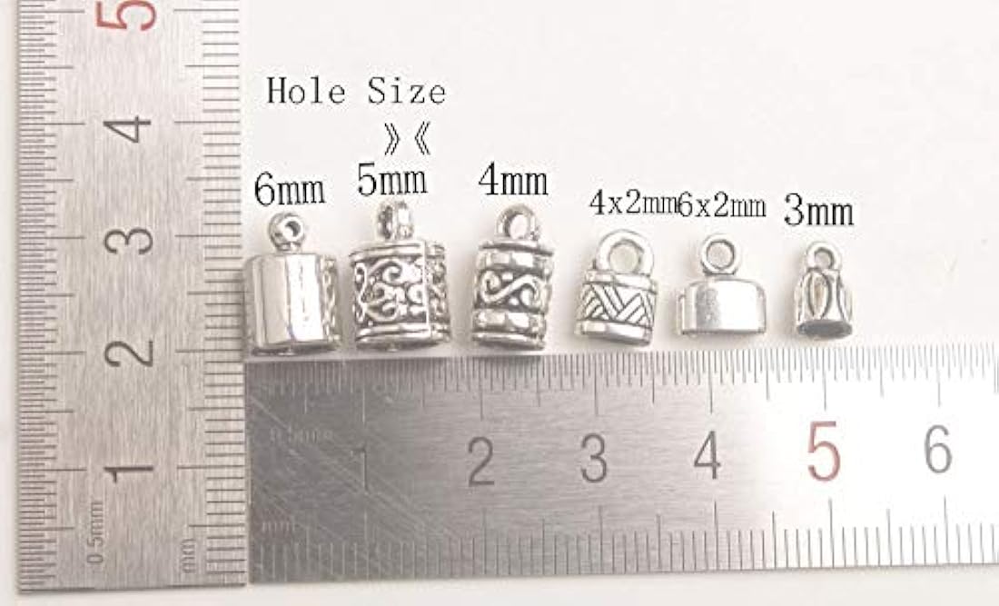 Dijes y Medallas una caja de 100 tapas de metal plateado